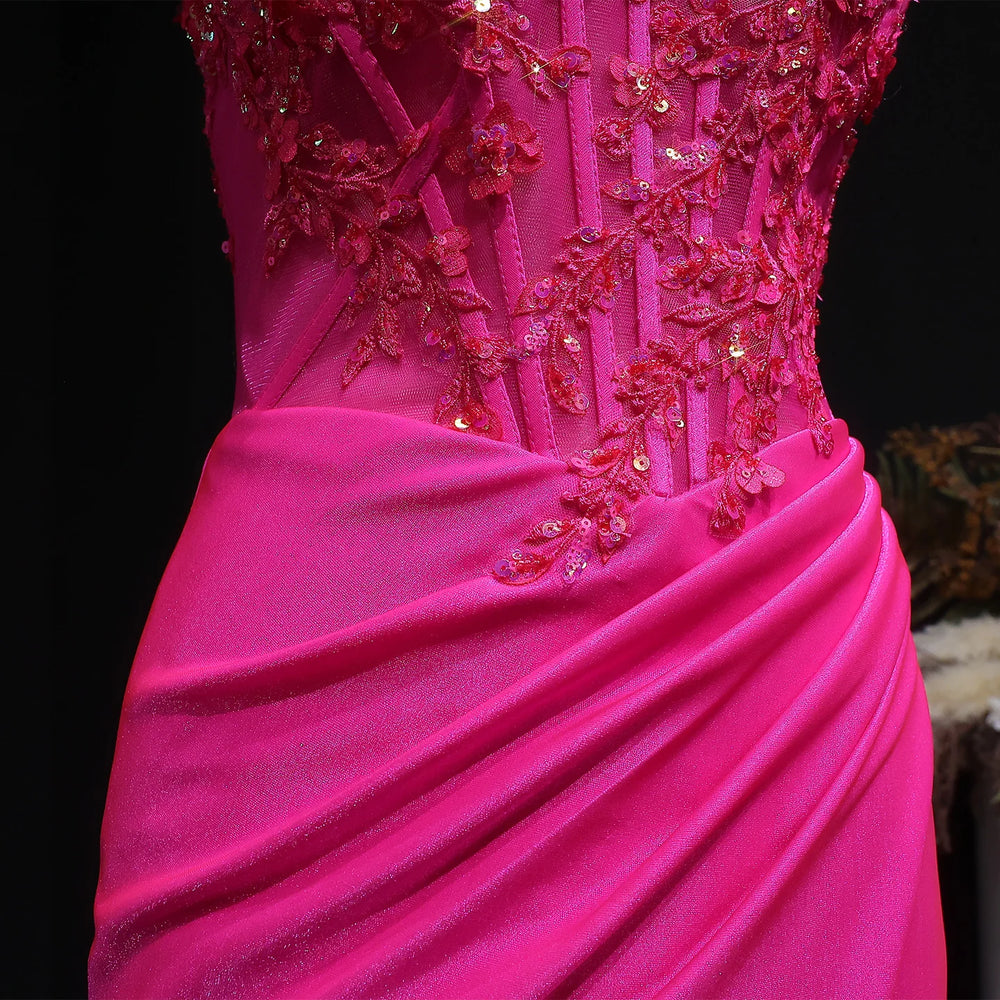 Close-up of a pink evening gown with intricate beadwork on a dark background