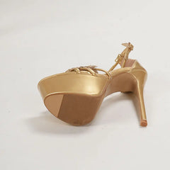 Gold high-heeled shoe lying on the floor