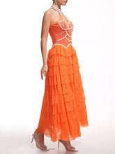 Orange evening gown with intricate detailing on a white background