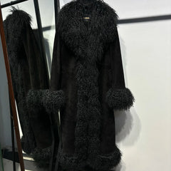 Black fur coat with matching gloves on a stand against a white wall