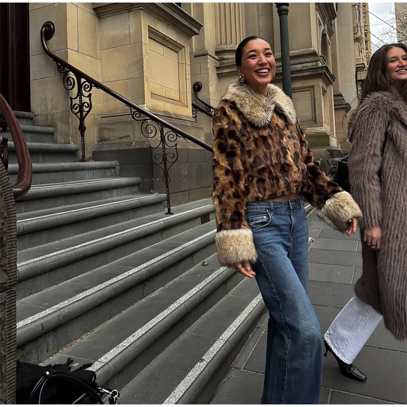 Two women standing on a city street, one wearing a leopard print coat with fur trim.