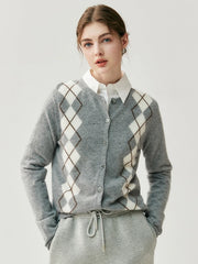 Person wearing a gray argyle sweater over a white shirt on a light background