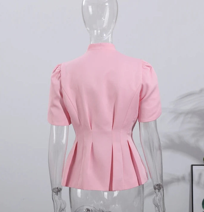 Pink blouse on a mannequin against a light gray background