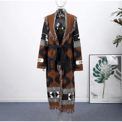 Mannequin wearing a patterned coat with a white wall and plant in the background