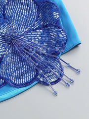 Close-up of a blue beaded flower accessory on a light gray background