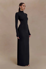 Woman wearing a black long-sleeve gown against a beige background