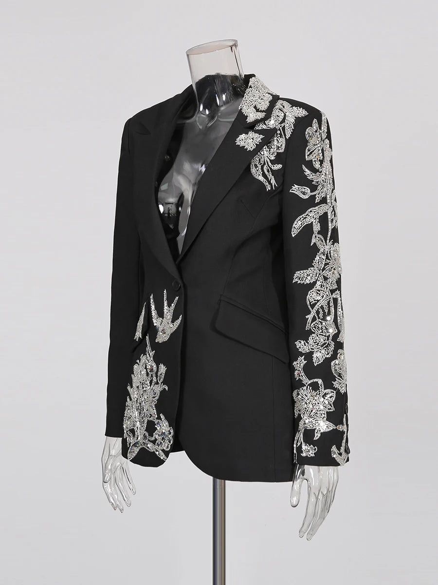 Black blazer with silver embroidery on a mannequin against a gray background