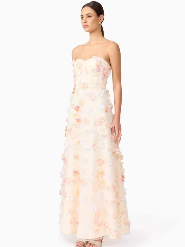 Woman wearing a strapless floral gown on a white background