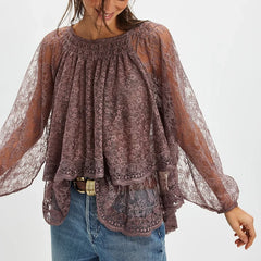 Woman wearing a sheer lace blouse with long sleeves on a white background