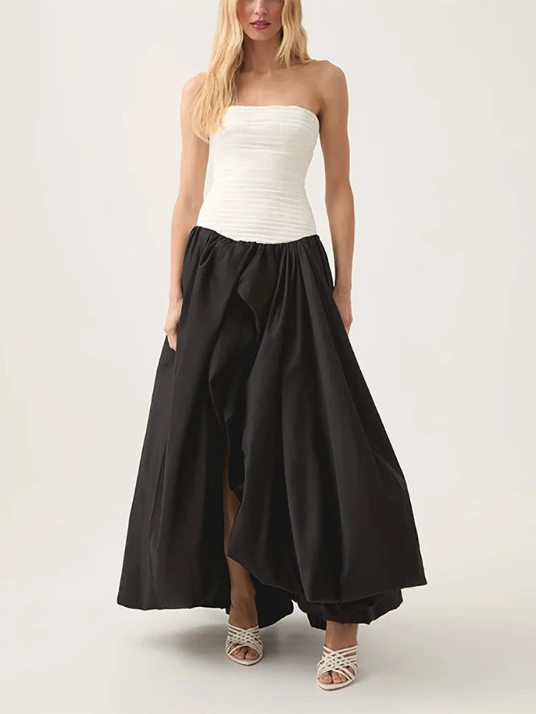 Woman wearing a strapless white top and black skirt on a white background