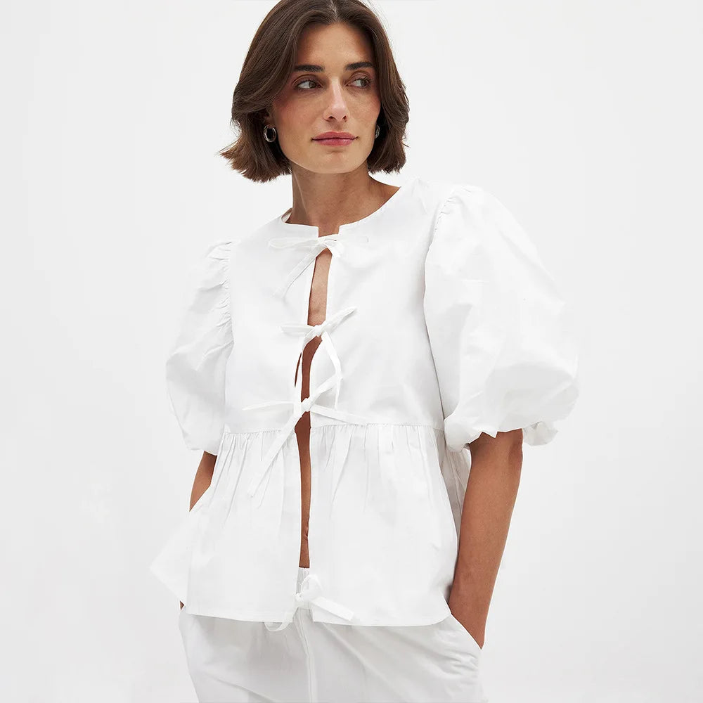 Woman wearing a white outfit with a plain background