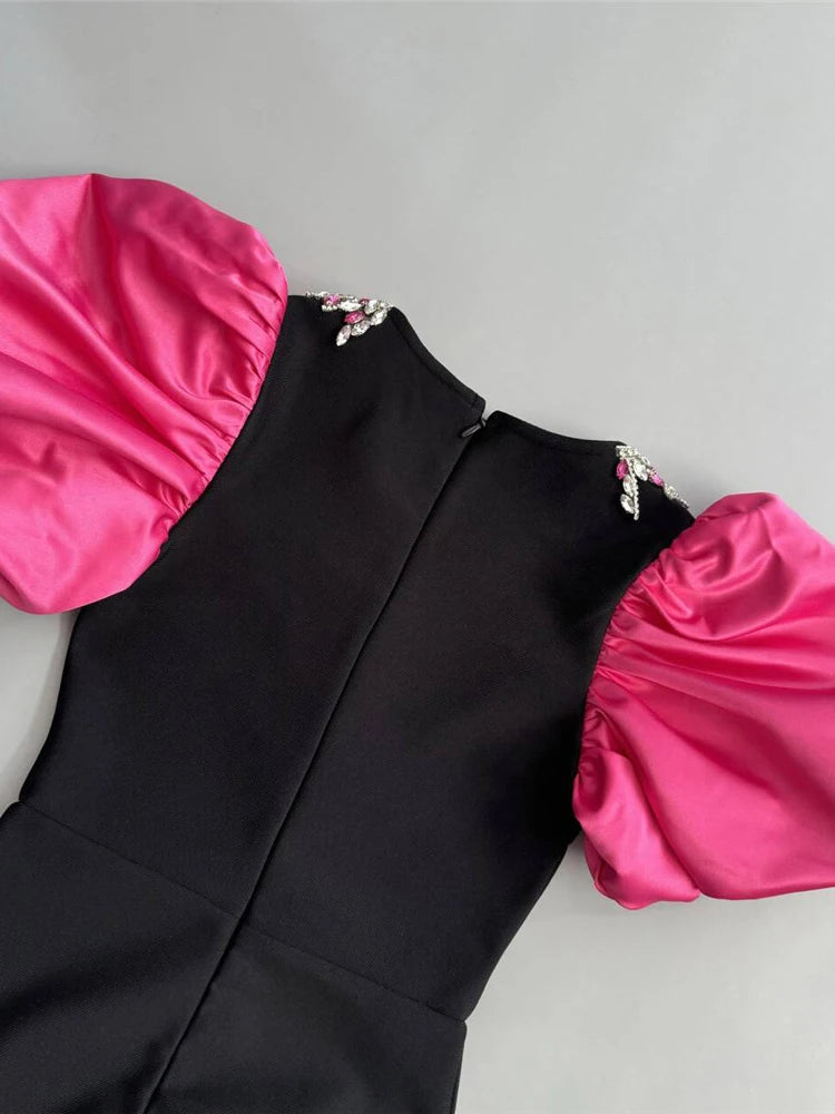 Black dress with pink sleeves and hem on a gray background