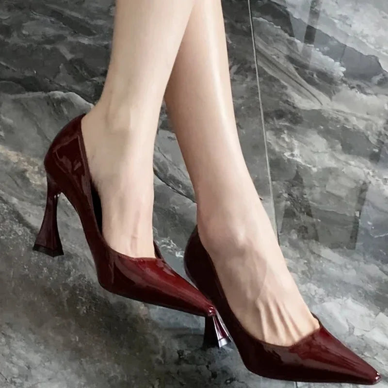 Red high-heeled shoes worn on a marble floor