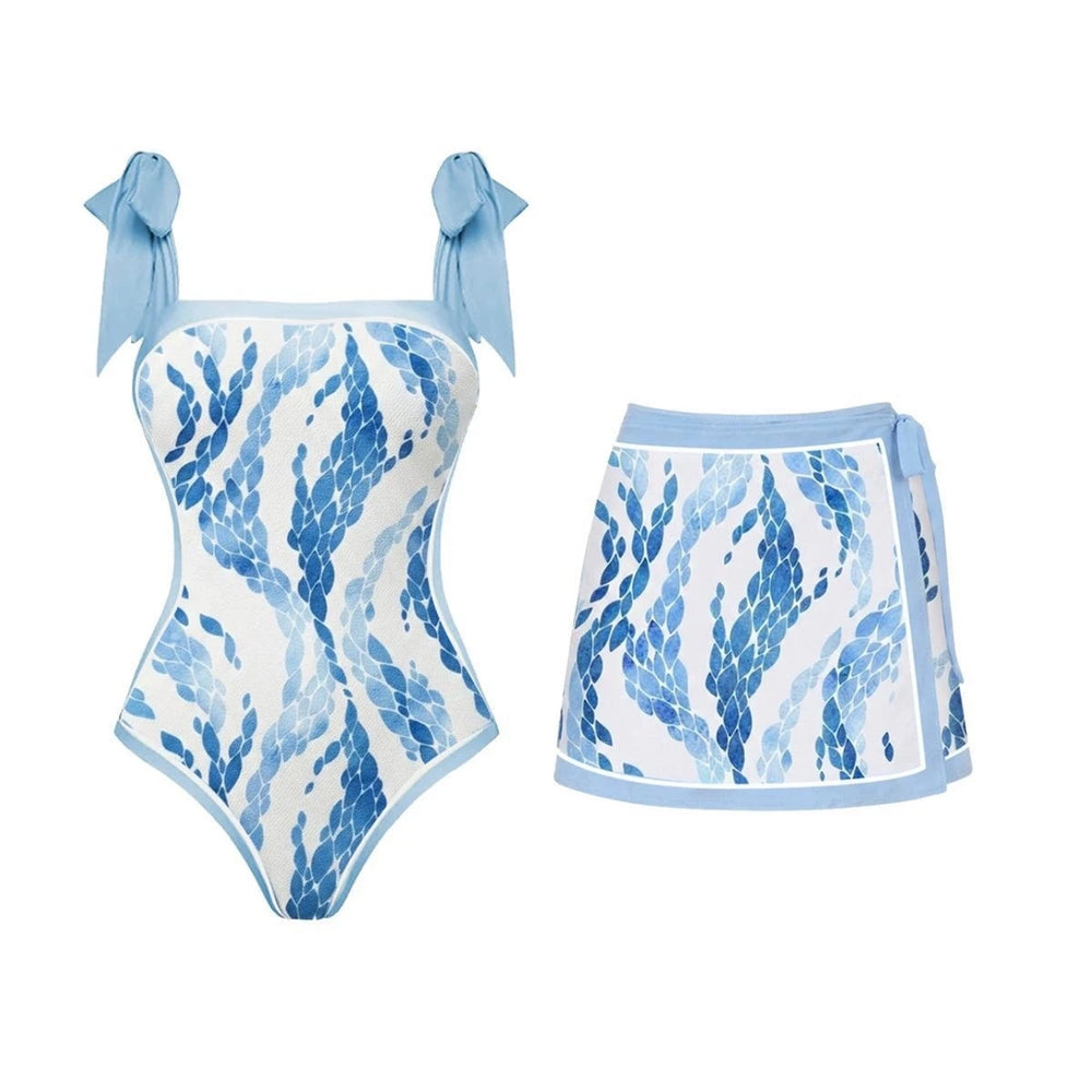 One-piece swimsuit with blue scale print and tie straps, paired with a tie-front mini skirt with matching print.