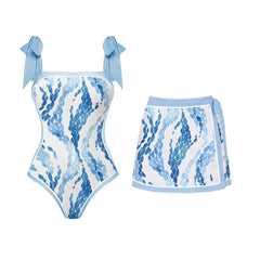One-piece swimsuit with blue scale print and tie straps, paired with a tie-front mini skirt with matching print.