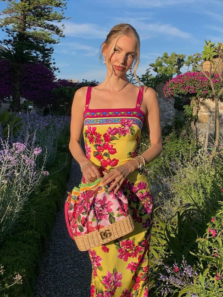 Woman in a colorful floral dress standing in a garden