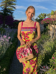 Woman in a colorful floral dress standing in a garden