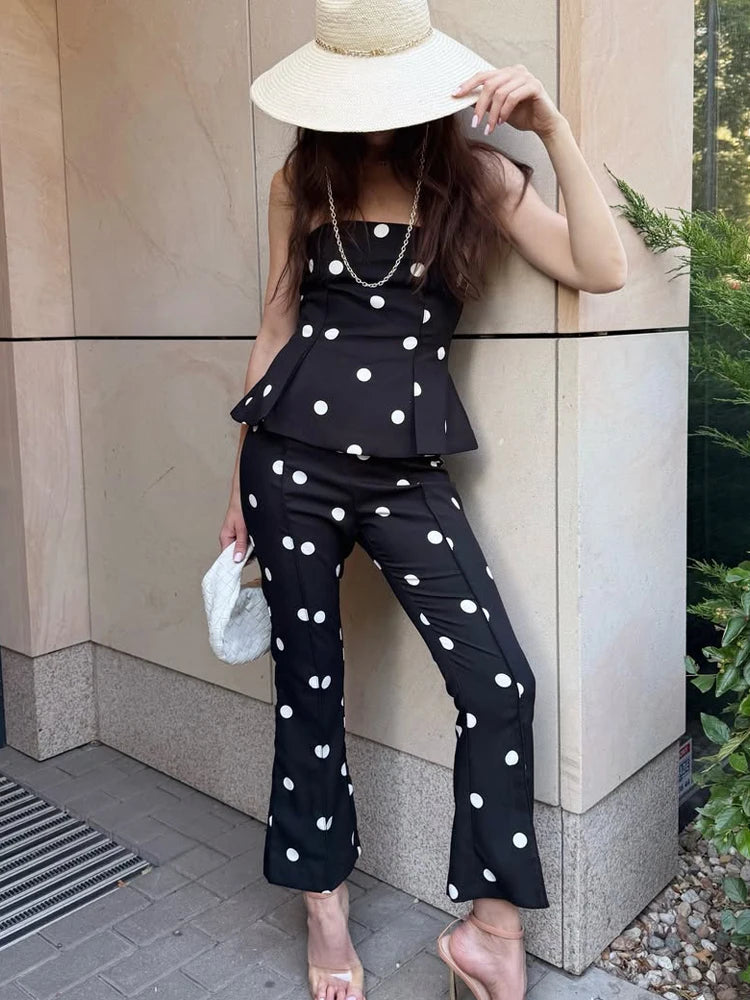 Woman in black polka dot strapless peplum top and flare pants with hat