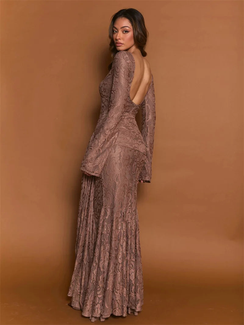 Woman wearing a long, elegant dress with a lace pattern against a brown background