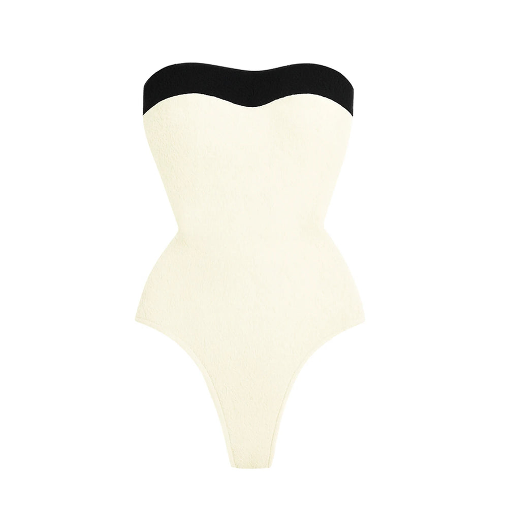 Textured cream swimsuit with black trim.