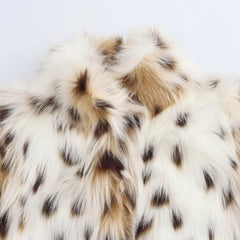 Close-up of a fur texture with white, brown, and black colors on a light gray background.