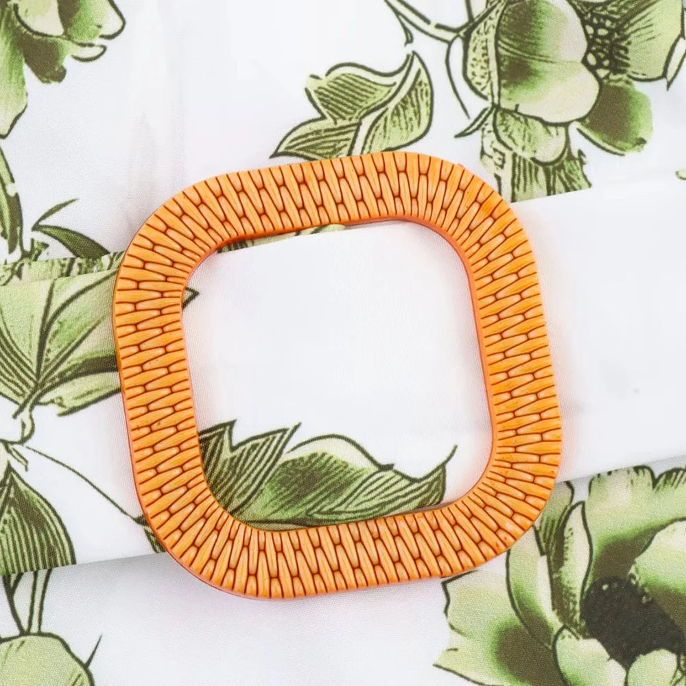 Orange woven square object on a floral patterned background