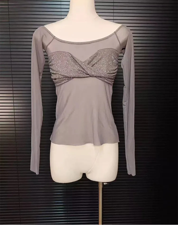 Gray long-sleeve top with a glittery front on a mannequin against a dark background