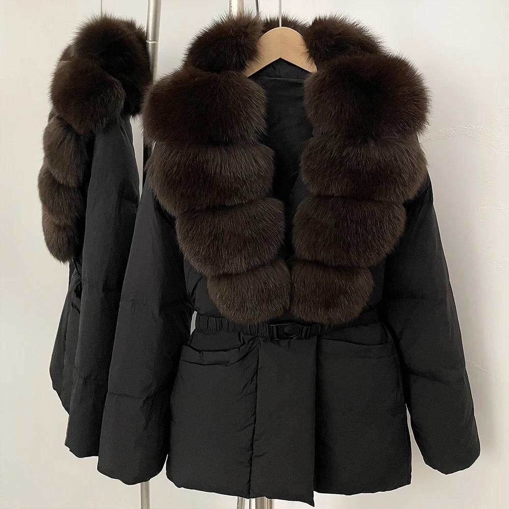Black winter coat with fur trim on a hanger against a plain background