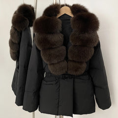 Black winter coat with fur trim on a hanger against a plain background