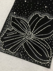 Black paper with white dot pattern on a textured surface