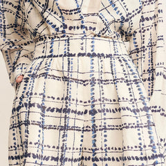 Plaid patterned garment with blue and white colors on a neutral background