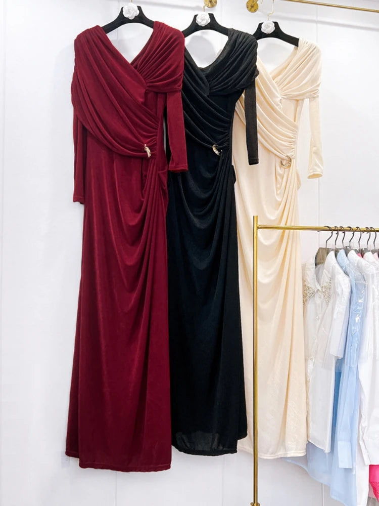 Three long dresses in red, black, and beige on hangers against a white background.
