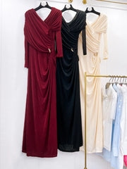 Three long dresses in red, black, and beige on hangers against a white background.