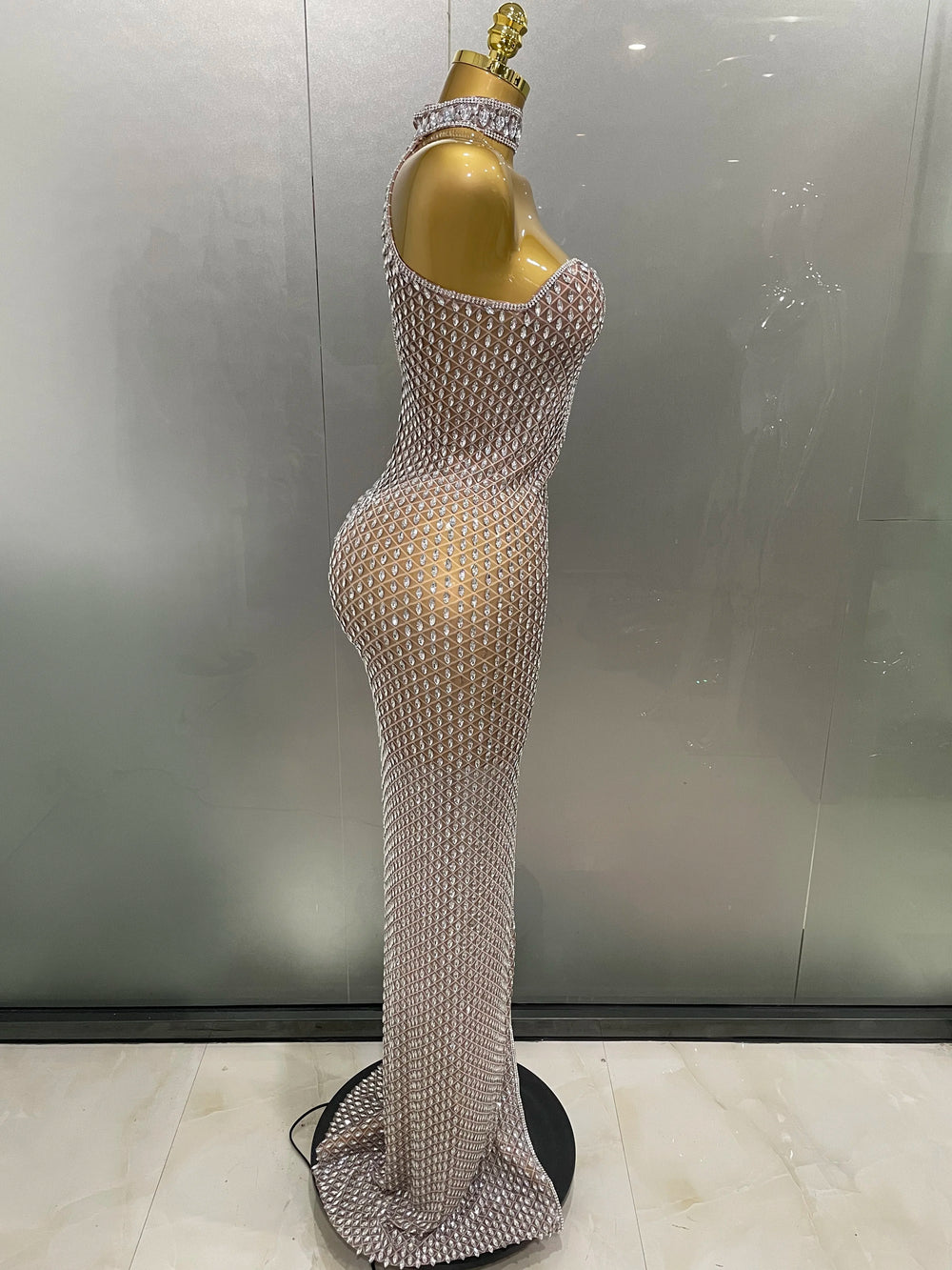 Mannequin wearing a sparkling silver evening gown against a neutral background