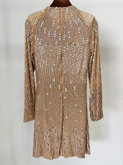 Back view of a gold beaded long sleeve mini dress on a hanger.