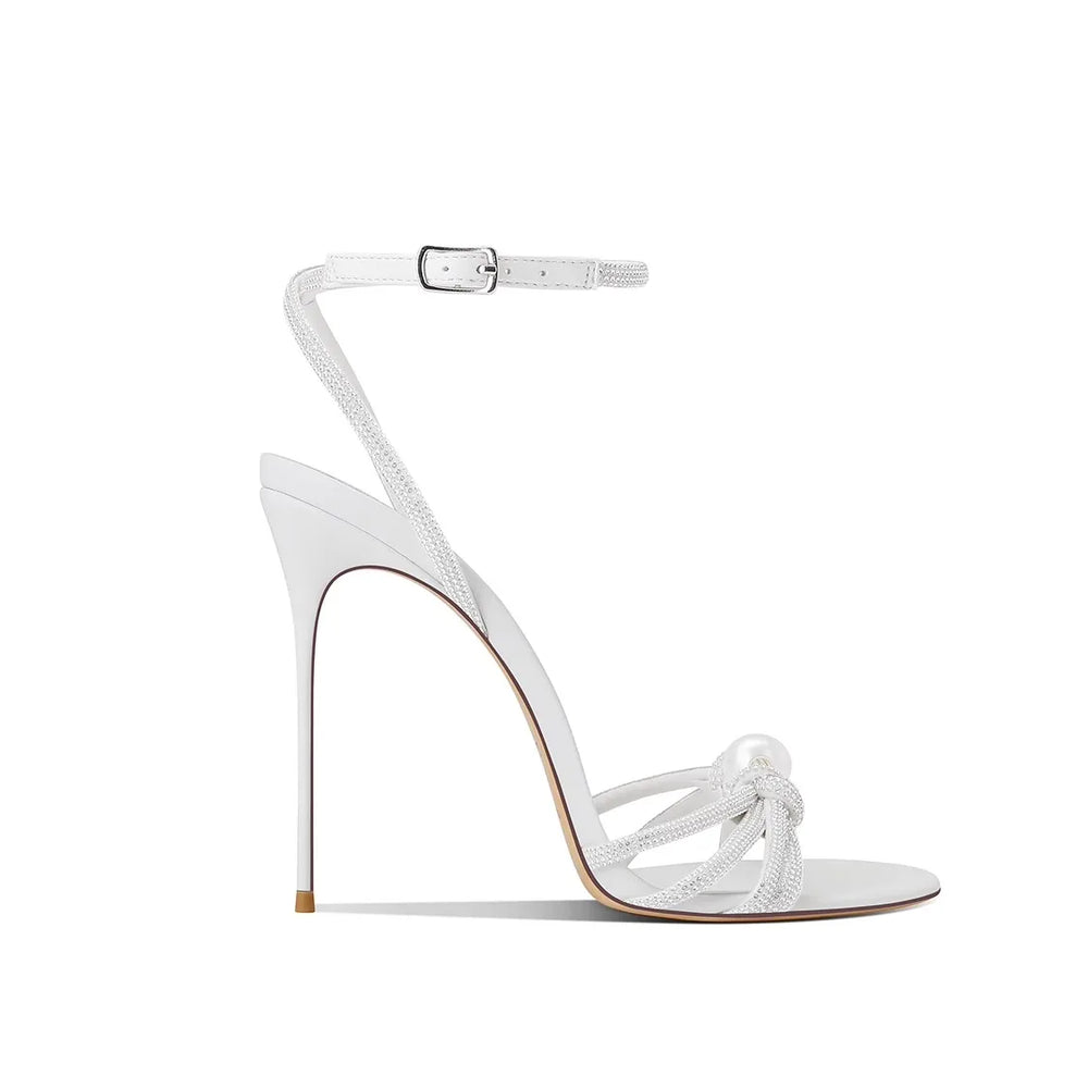 White high-heeled sandal with ankle strap on a white background