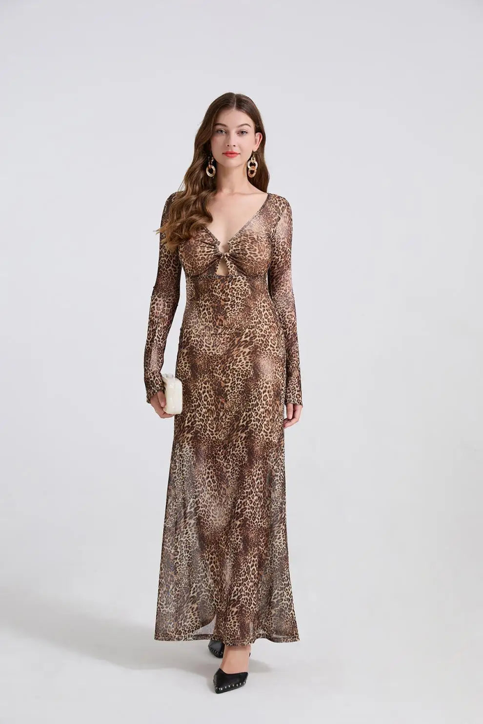 Woman wearing a long, patterned dress against a white background