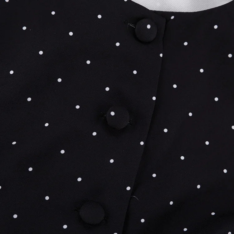 Close-up of a black polka dot dress with buttons.