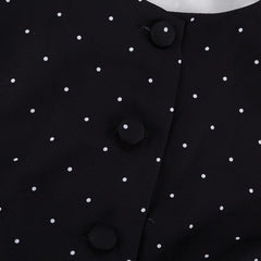 Close-up of a black polka dot dress with buttons.