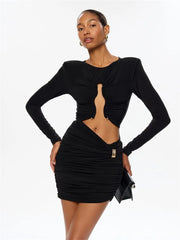 Woman wearing a black long-sleeve dress with cut-out design on a white background