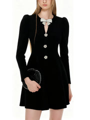 Black dress with decorative buttons and a bow