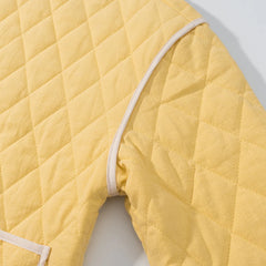 Yellow quilted cover on a white surface