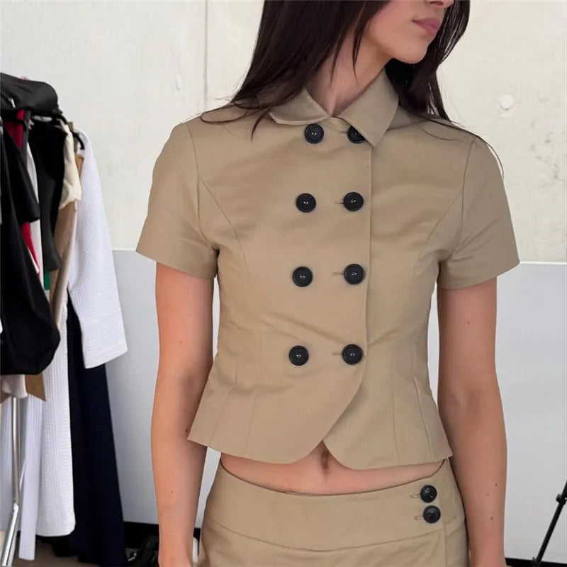 A woman wearing a beige double-breasted top in a clothing store.