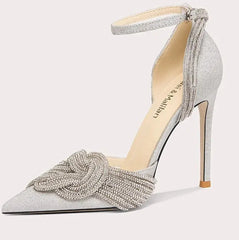 Silver high-heeled shoe with decorative bow on a white background