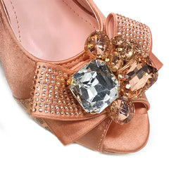 Rose gold shoe with decorative gemstones on a white background