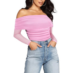 Woman wearing a pink off-shoulder top and blue jeans on a white background