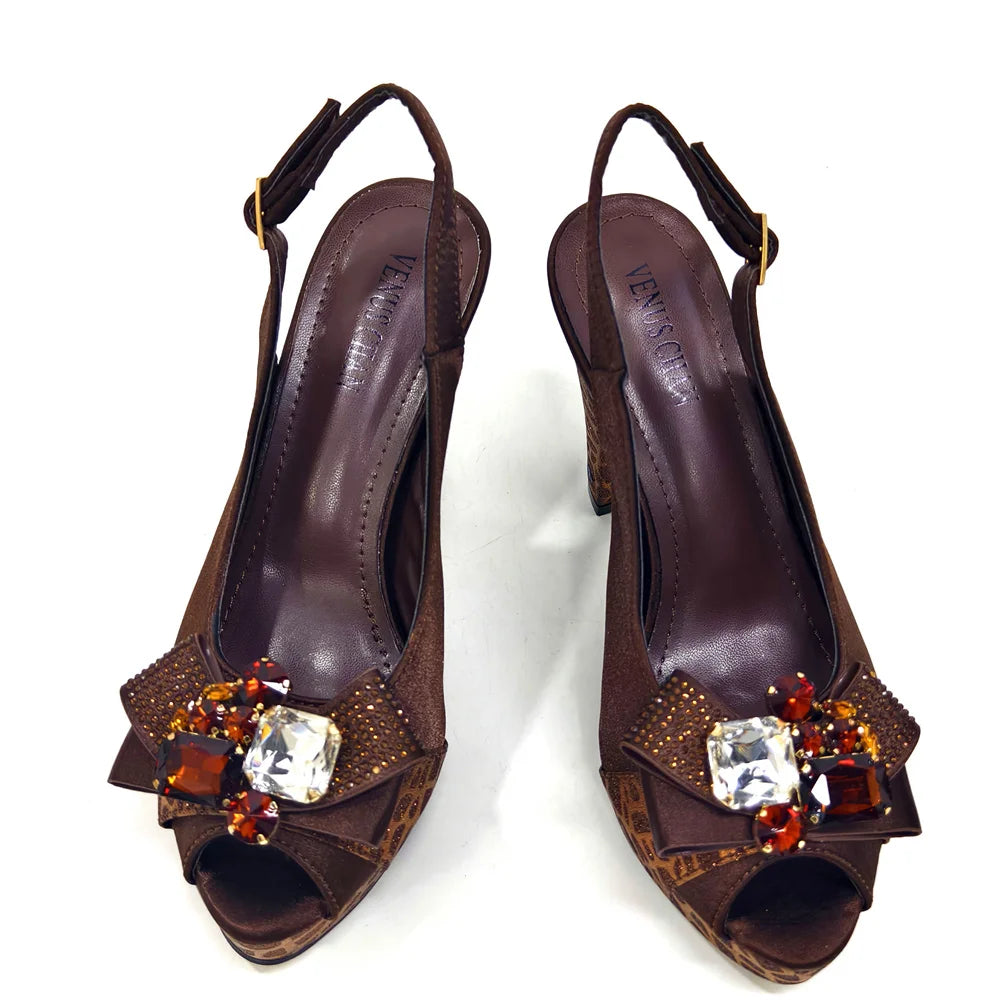 Pair of brown high-heeled shoes with decorative embellishments on a white background