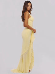 Woman wearing a yellow evening gown on a plain background