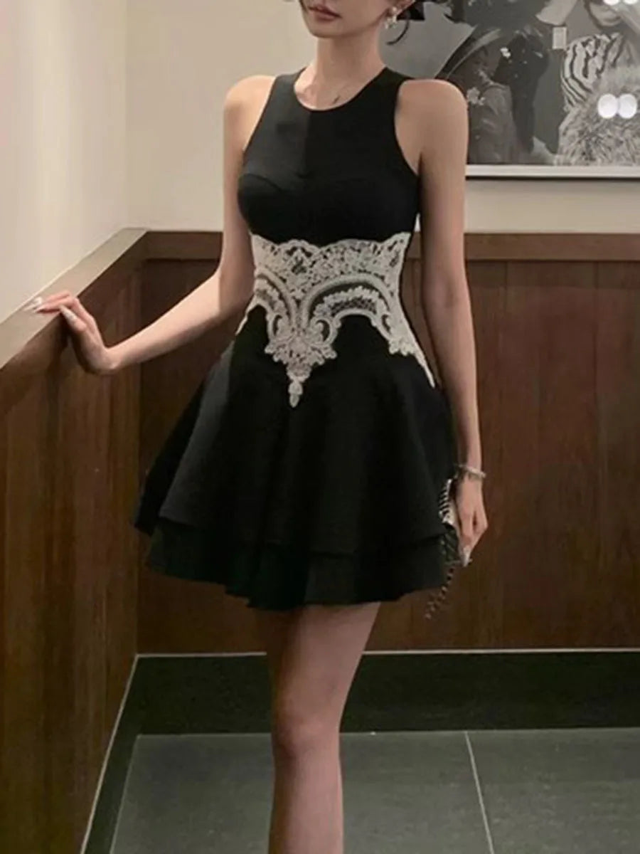 Black dress with white lace details worn by a person indoors.