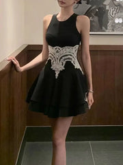 Black dress with white lace details worn by a person indoors.
